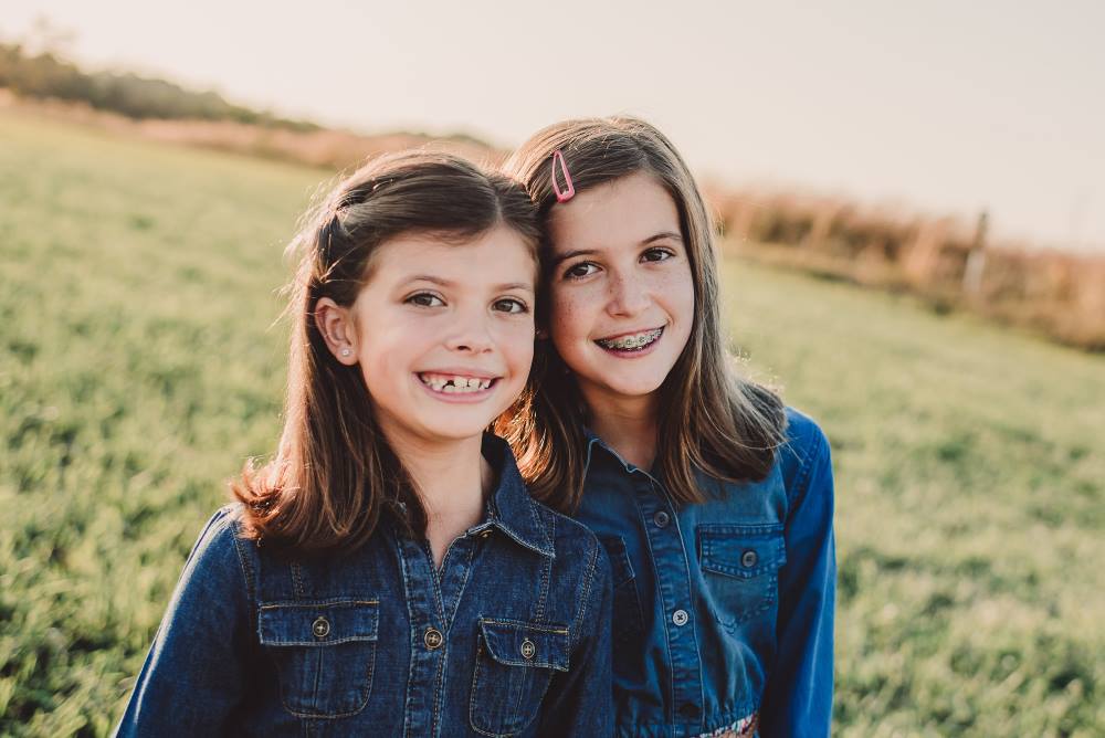 Two friends smiling together, showcasing the confidence and positive impact of orthodontic care.