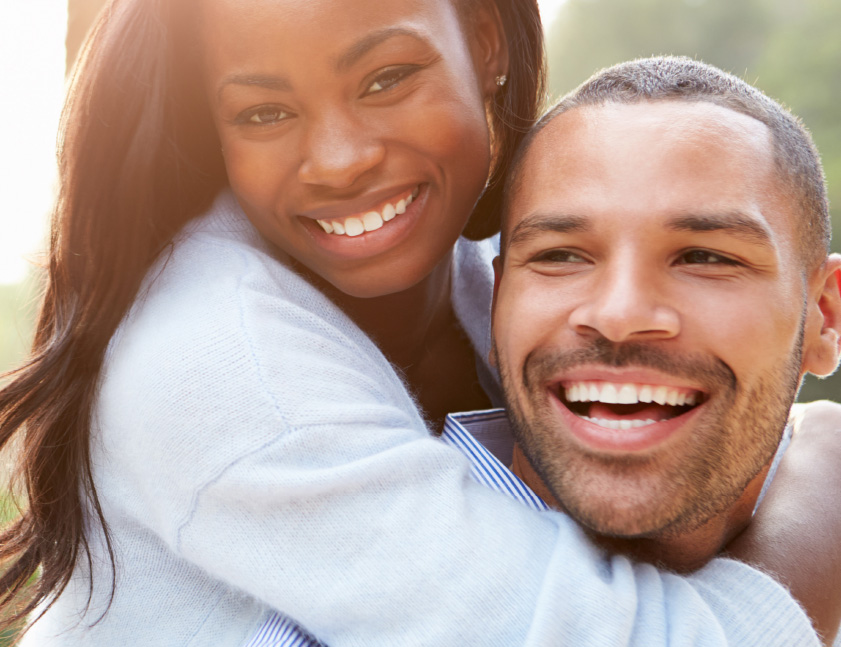 Smiling man and woman, symbolizing the joy and confidence that comes from a healthy smile, encouraging new patients to refer friends and family.