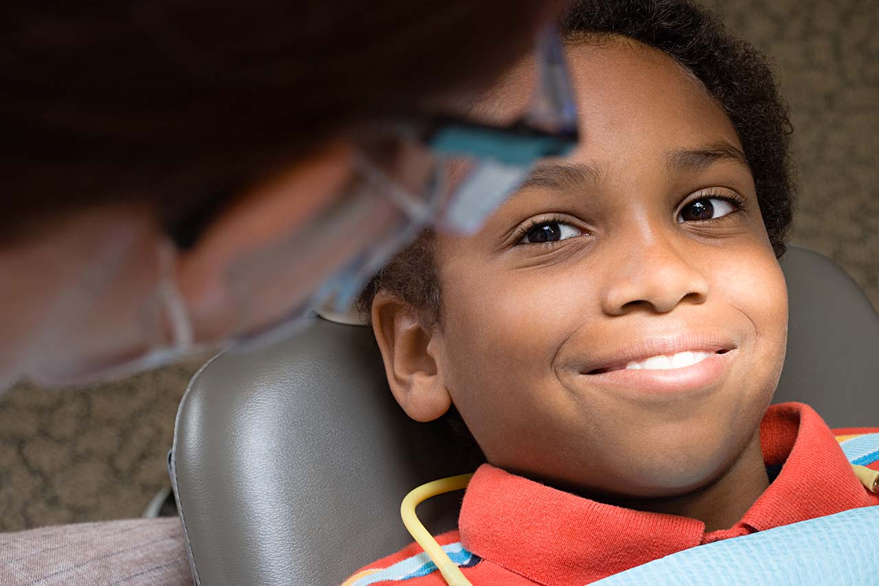 Smiling young boy in orthodontist's chair receiving two-phase treatment