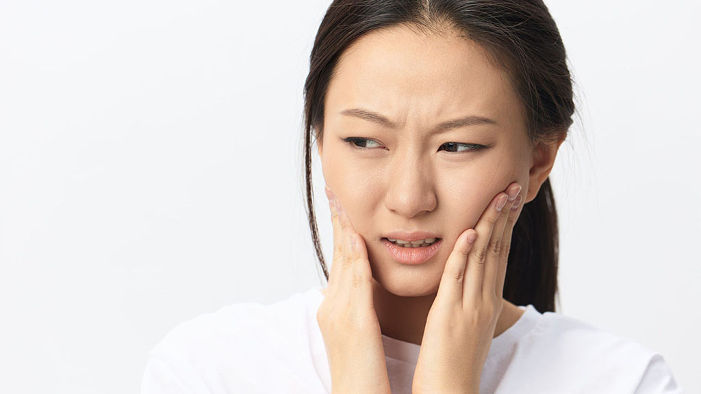 Woman experiencing orthodontic pain, touching cheeks, emergency dental care, jaw pain, toothache, orthodontic emergency